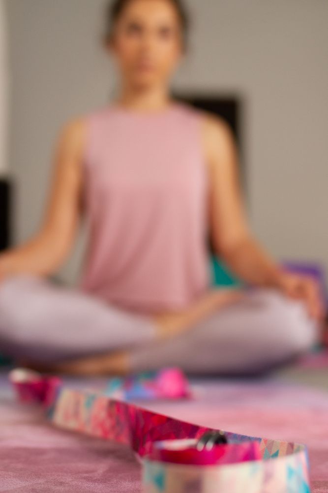 Woman in lotus pose among sports equipment