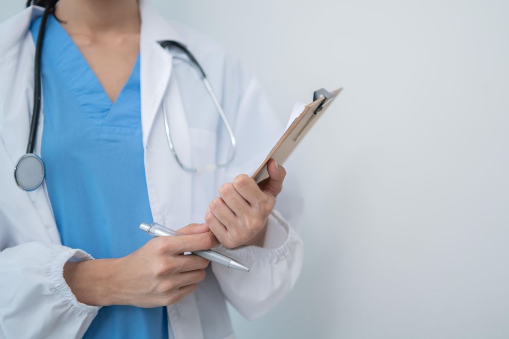 Mid shot of doctor standing in light hospital room with copy space