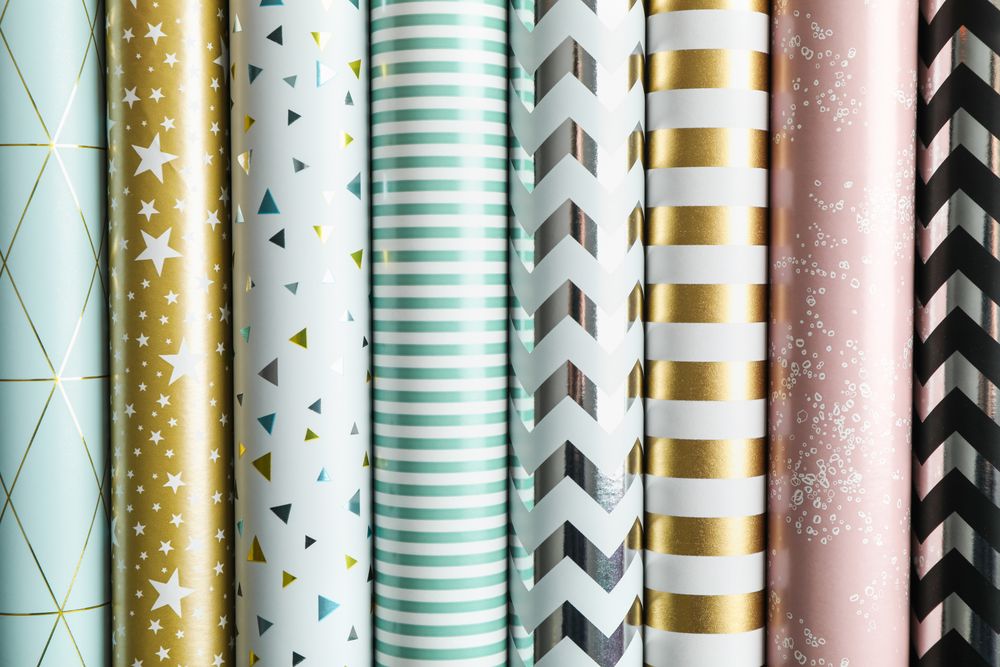 Rolls of festive wrapping paper as background. Top view