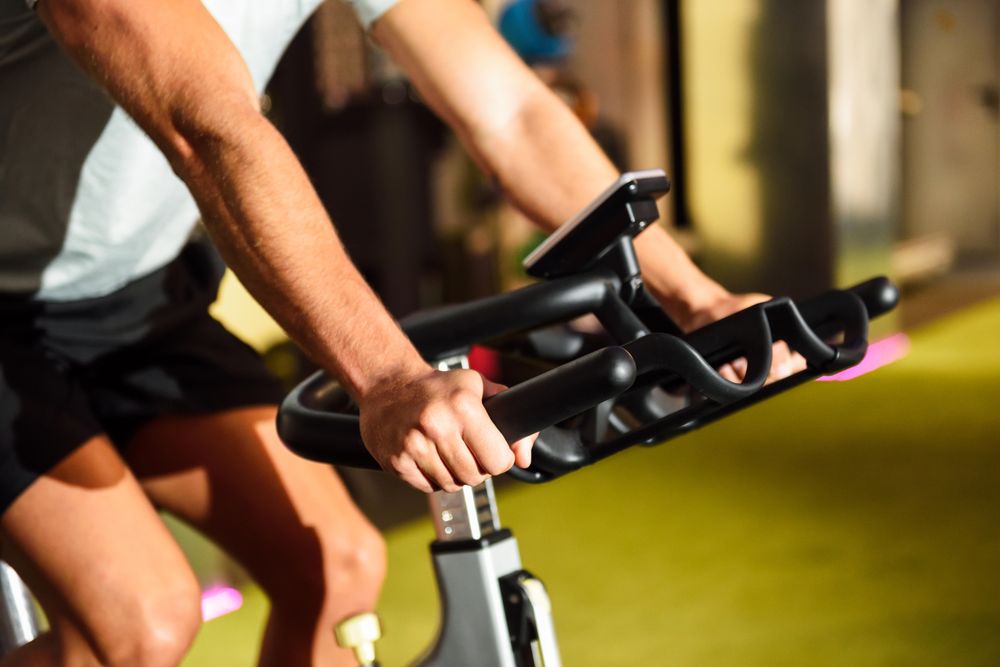 Hands of a male training at a gym doing indoor biking