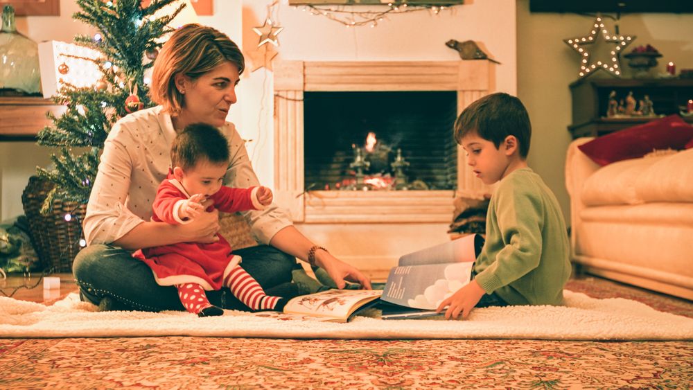 Mother reading book with son on Christmas eve