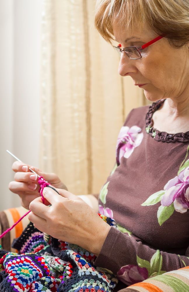 Portrait of woman knitting a vintage wool quilt