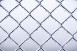 Metal wire fence covered with snow