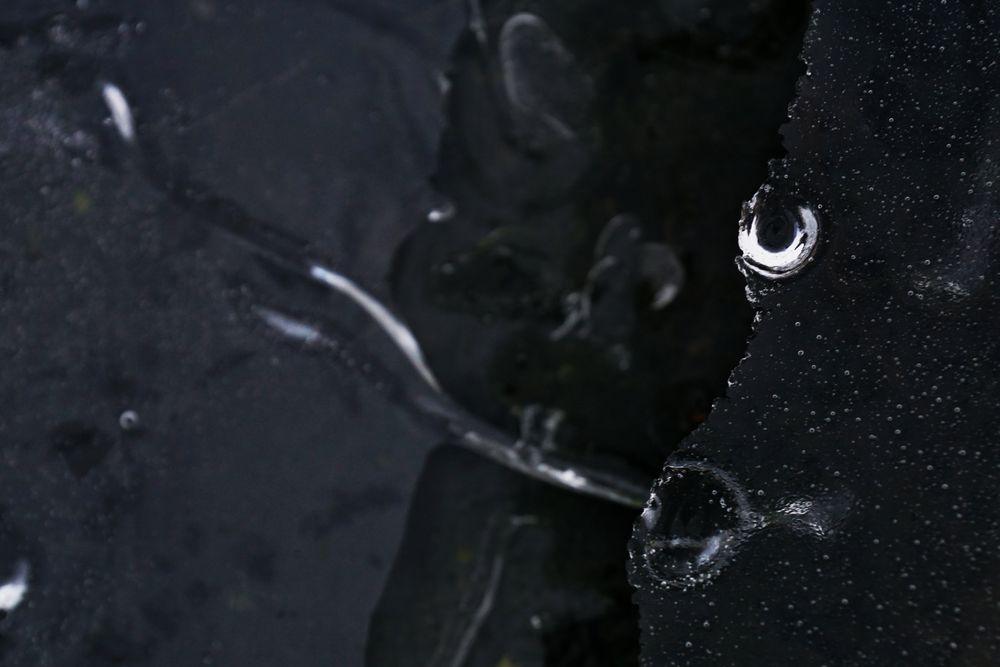 Fragment of thin ice on dark frozen river
