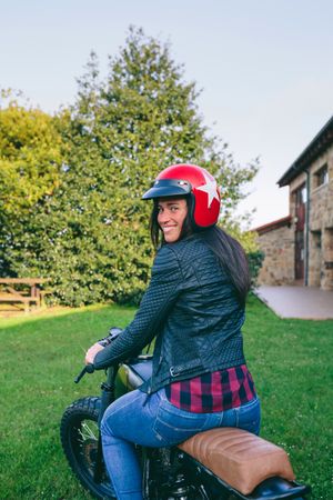Woman with helmet riding custom motorbike