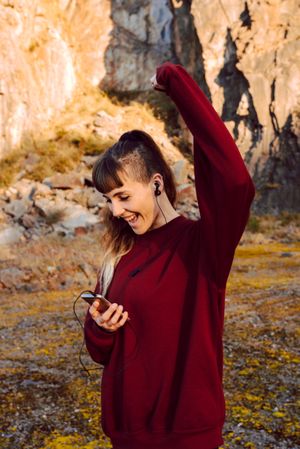 Young woman with smartphone dancing