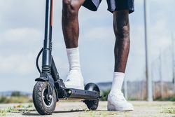 Black man riding on electric scooter in park