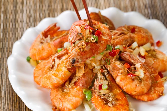 Fried bread coated shrimp and garnishes on serving plate ready to eat