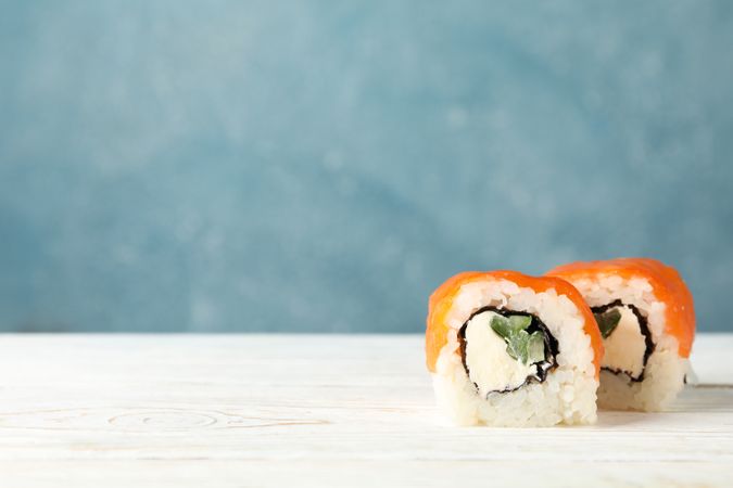 Delicious sushi rolls on wooden table, space for text. Japanese food