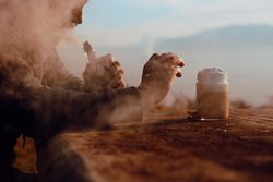 Vaper puffing smoke and taking shot of coffee