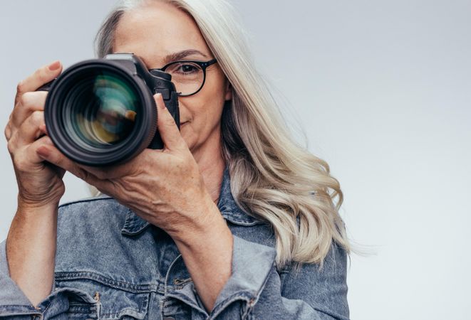Mature female photographer taking pictures with dslr camera