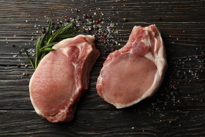 Composition with raw meat for steak and spices on wooden background