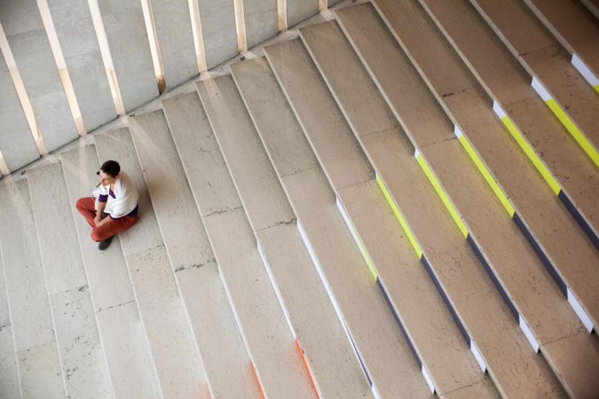 Top view of a man sitting on wide staircase