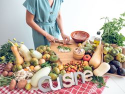 Crop female cutting vegetables on board while preparing healthy food