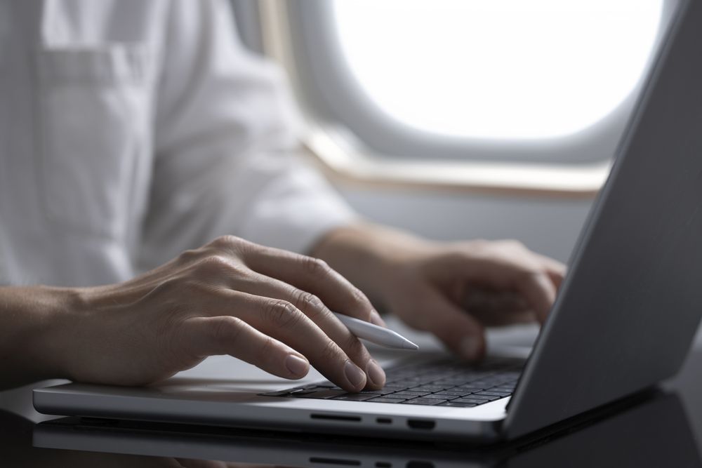 Businessman Working on Laptop in Airplane