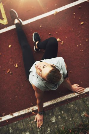 Top view of woman relaxing on running track