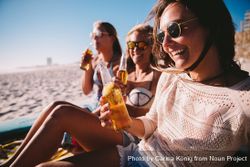Group of young women drinking beer at the beach x42ogb