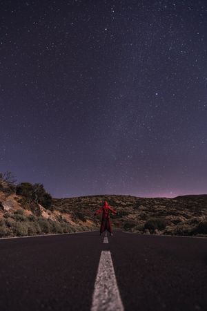 Traveler standing on empty road at night
