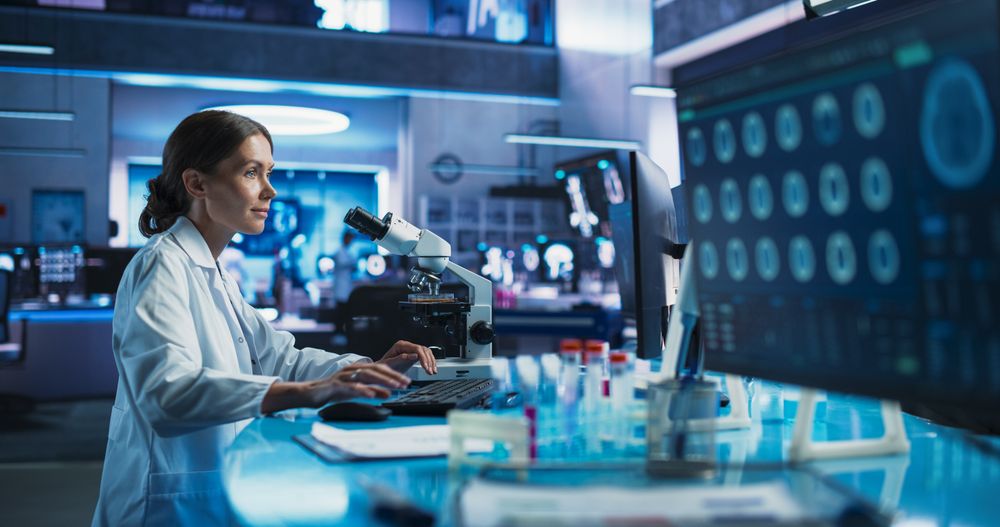Medical Research And Development Center: Female Scientist Using Microscope To Analyze Petri Dish Sample.