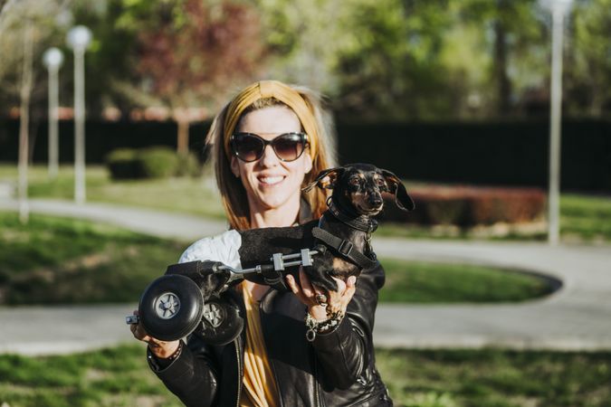 Woman showing dog with wheelchair on street