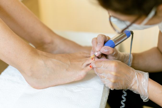 Nail varnish being removed from female feet in professional salon