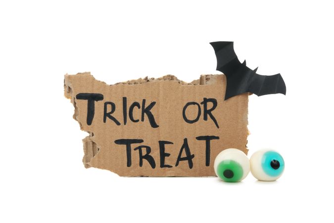 Carton with text Trick or treat, bat and eye isolated on blank background