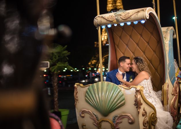 Just married couple in wedding suits taking amusement rides