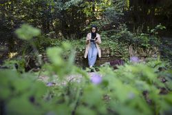 Middle Eastern woman in park bench with book