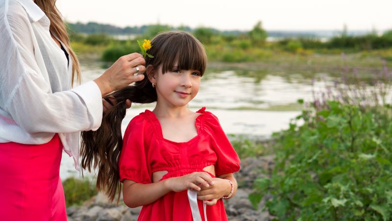 Mom weaves fresh flowers into daughter's braid