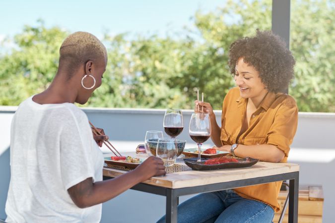 Smiling diverse girlfriends enjoying meal in restaurant