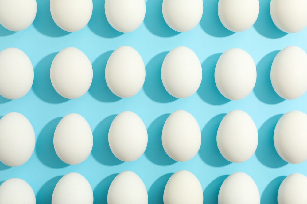 Flat lay composition with chicken eggs on color background, space for text