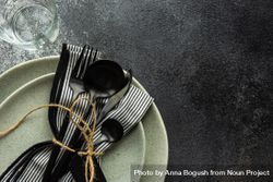 Top view of table setting with dark cutlery & string on concrete background with copy space 0V6Ox3