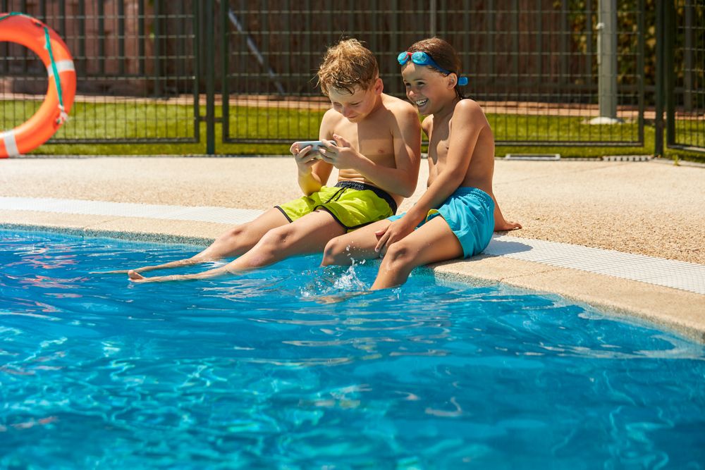 Boys on poolside taking selfie