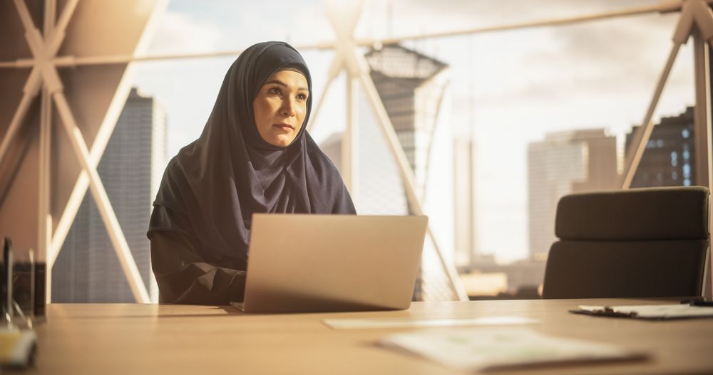 Portrait of a Young Female Business Account Manager Working on a Laptop Computer in a Modern Corporate Office.
