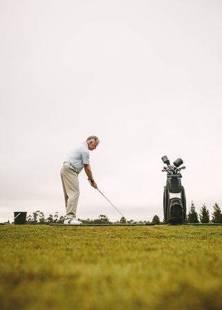 Full length of mature male golfer practicing for golf tournament