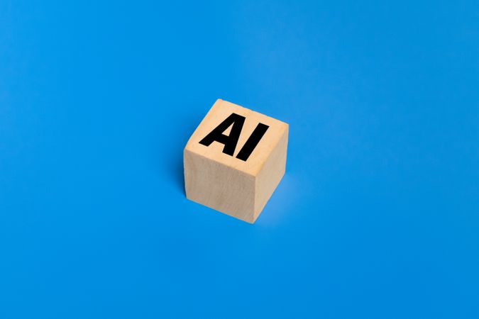 AI symbol or artificial intelligence on wooden blocks. isolated on blue background