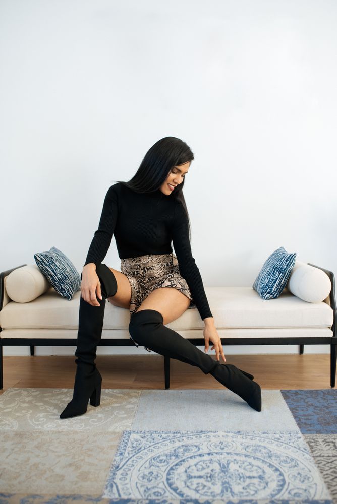 Stylist beautiful young Black woman sitting in a couch