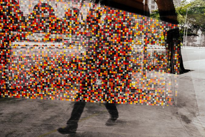 Reflection of mosaic as someone walks