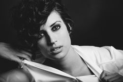 Woman ripping off shirt in dark studio shoot