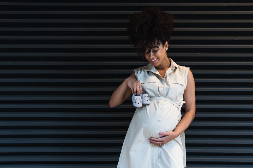 Smiling Black woman showing baby booties