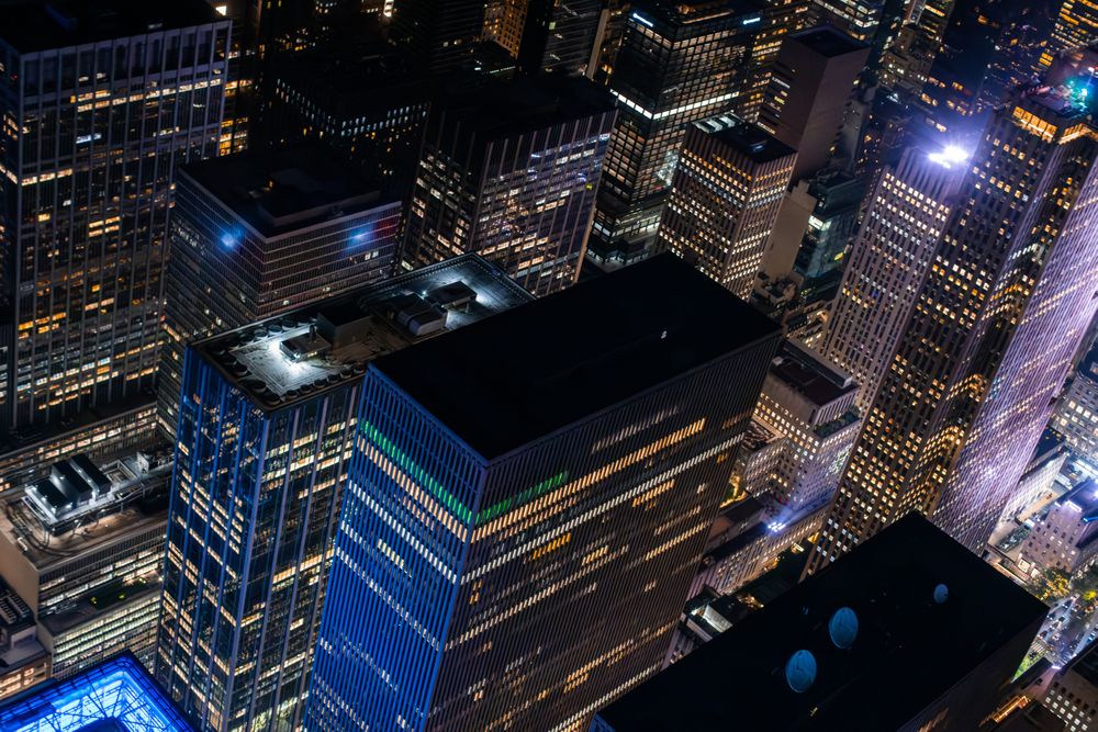 New York City Aerial Night Cityscape with Stunning Manhattan Landmarks, Skyscrapers and Residential Buildings. Helicopter Down View of the Urban Architecture