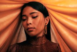 Young woman looking down with head draped in fabric