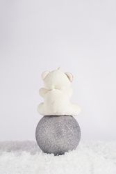 Bear sitting on gift box, vertical