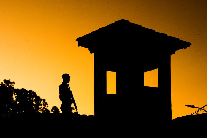 Silhouette of man standing near building during sunset