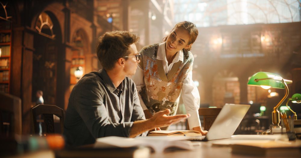 Engaged Female Student Discussing Academic Material with Male Peer in a Historic Library.