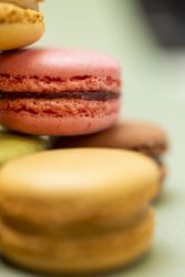 Colored tasty raspberry macaroon on a green table