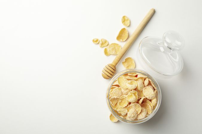 Dipper and jar of muesli on plain background