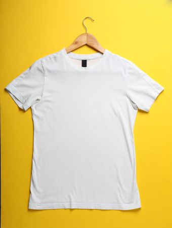 Hanger with blank plain t-shirt on yellow background, space for text