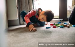 Kid playing on the floor with toys at home 4mdBe5