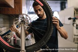 Man working on a bicycle wheel in a repair shop 41maL4